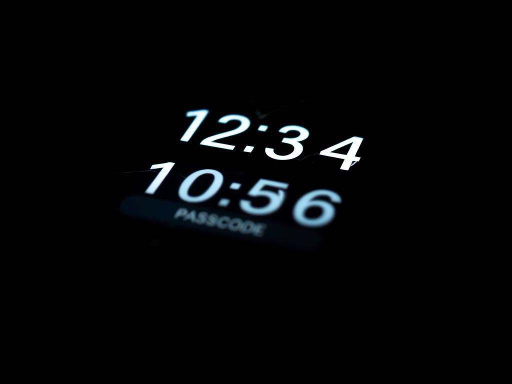 a close-up view of a smartphone screen displaying a numeric passcode interface, with the numbers illuminated against a dark background. the screen is slightly cracked, suggesting the device has been through some wear and tear. the passcode appears to be blurred or obscured, indicating the focus is on the interface itself rather than revealing any sensitive information. the lighting is low-key, casting dramatic shadows across the screen and creating a sense of tension and mystery. the camera angle is slightly tilted, adding a sense of unease and drawing the viewer's attention to the passcode as the central focus of the image.